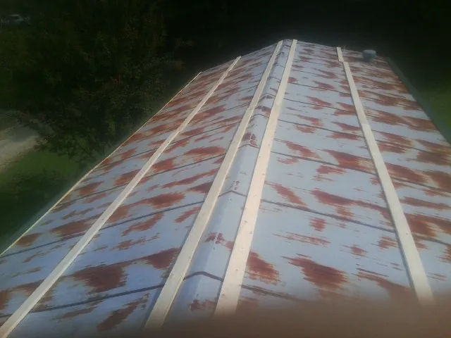 Rusted metal roof panels with new wood purlins before replacement — Storm Damage Roof Repair in Okmulgee by Roofing Brothers