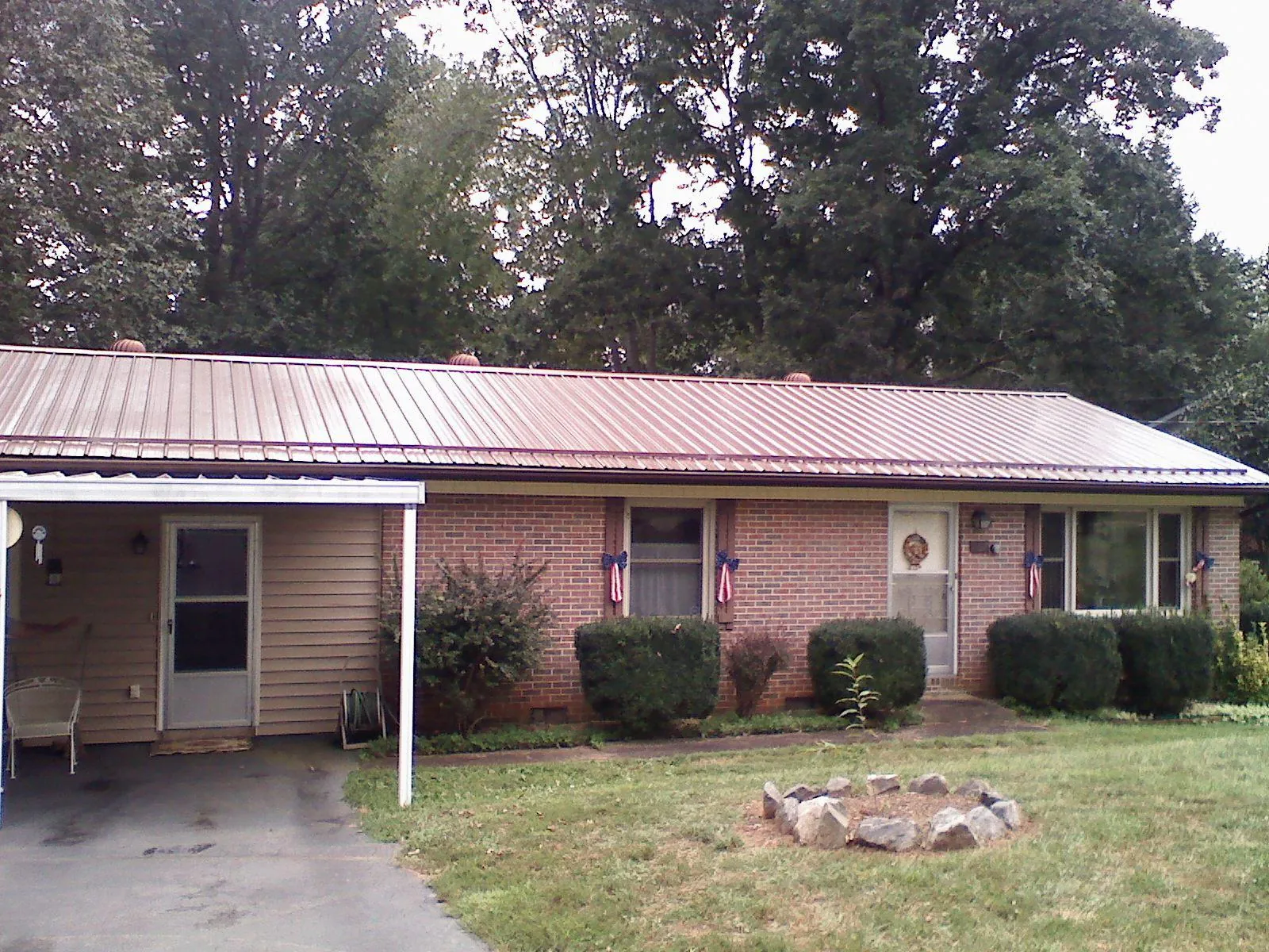 Bronze metal roof and carport on a brick ranch home — Roof Repair work by our crew in Okmulgee