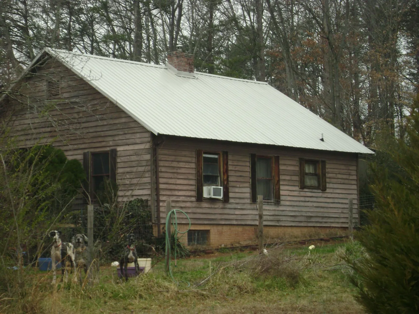 White metal roof on an old wood sided farmhouse, from a Metal Roof Installation job in Okmulgee